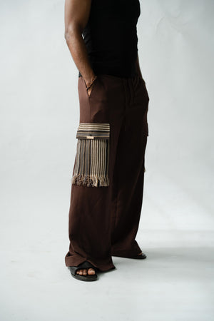 Premium African luxury cargo pants in rich brown fabric with handcrafted striped Aso Oke pocket accents.