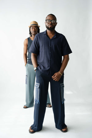 Modern African-inspired men's navy cargo trousers with handcrafted Aso Oke pocket detailing and relaxed silhouette