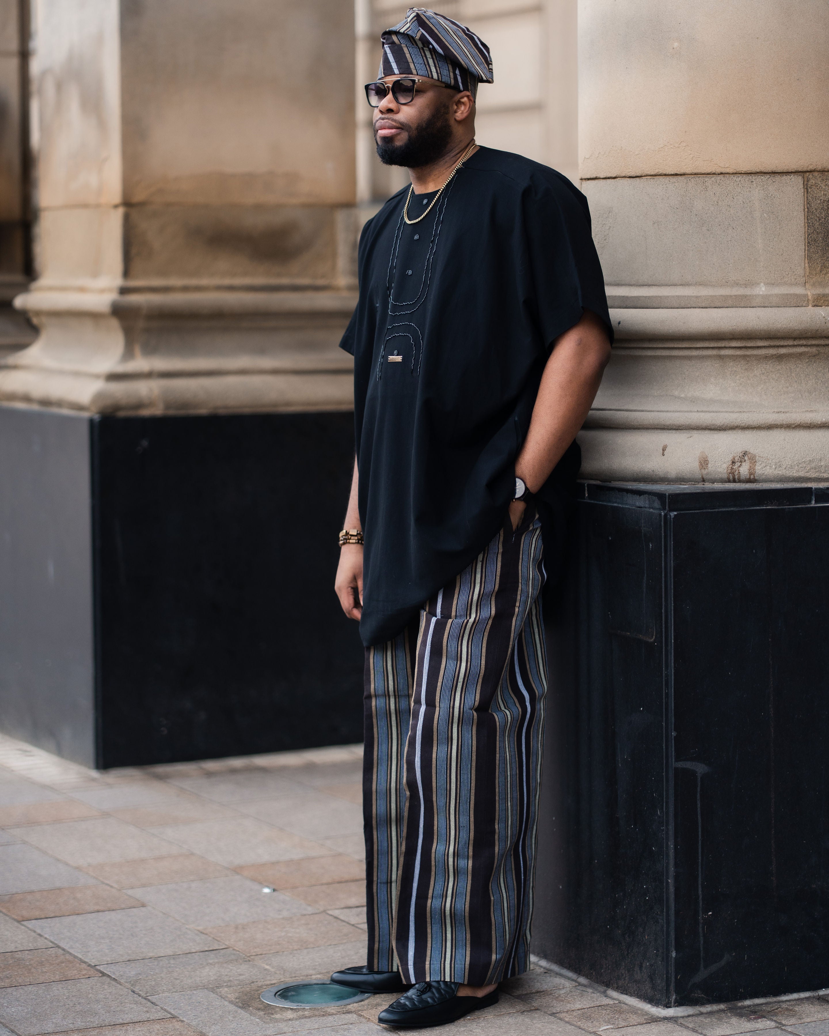 Balogun Aso Oke Set featuring a black tunic and striped Aso Oke trousers