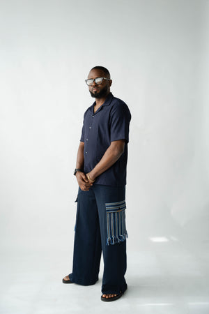 Contemporary African menswear outfit featuring navy resort shirt and Aso Oke cargo trousers