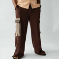 Brown wide-leg cargo trousers for men featuring handcrafted Aso Oke cargo pockets with fringe detailing, front view.