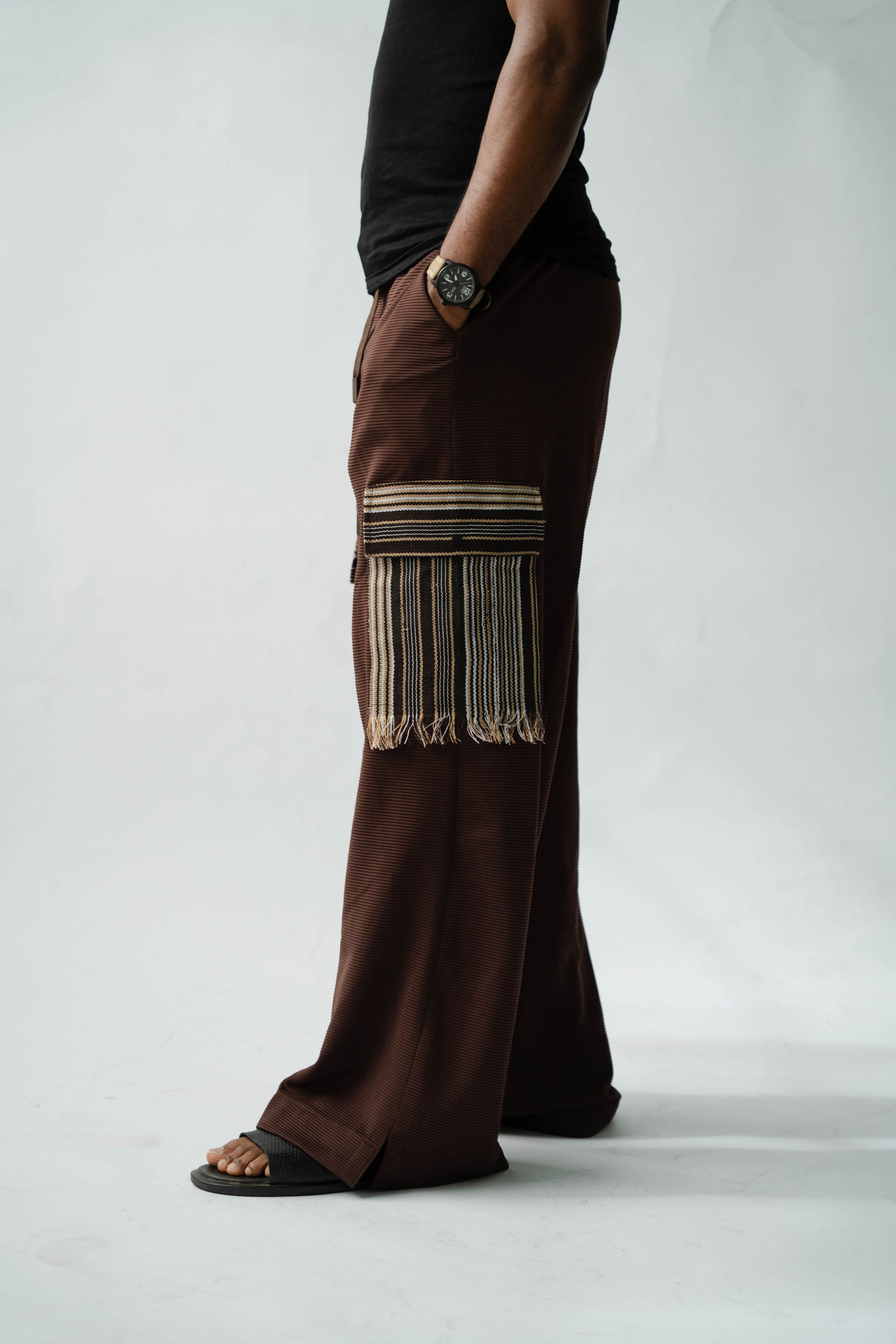 Luxury brown wide-leg men's trousers with statement Aso Oke cargo pockets and contemporary African-inspired design