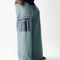 Luxury Pale Blue wide-leg cargo trousers for men featuring handcrafted Aso Oke pockets, premium textured fabric, drawstring waist and contemporary African-inspired design. This designer statement piece blends traditional craftsmanship with modern menswear styling.